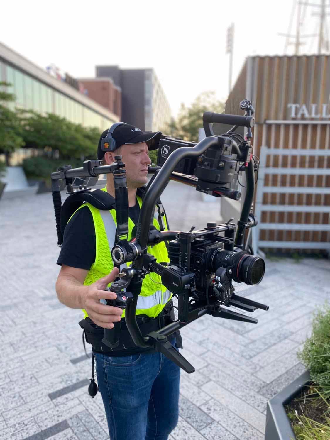Director of Photography walks with a large 3-axis gimbal